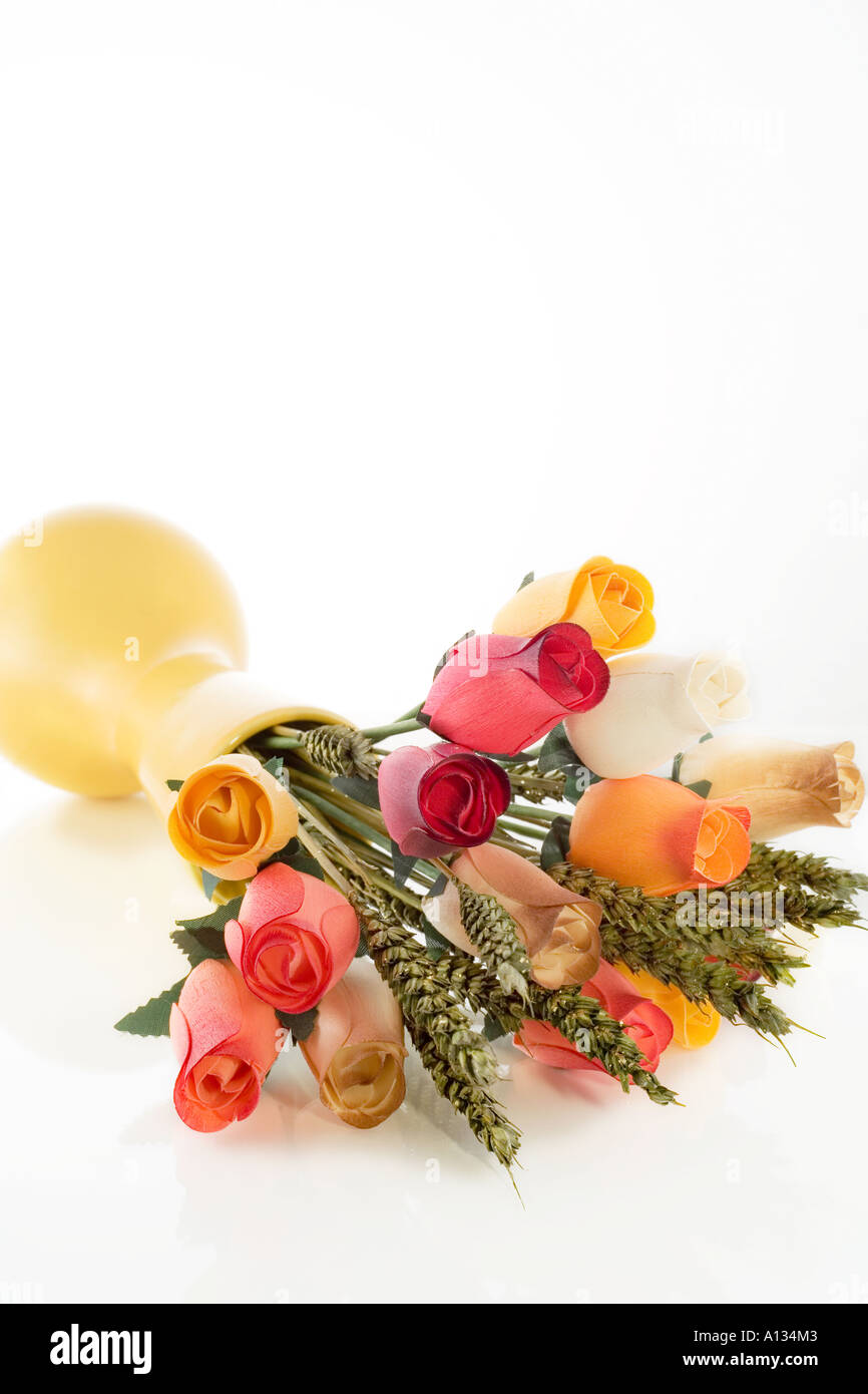 bouquet of wooden roses and dry plants in yellow vase on white ...