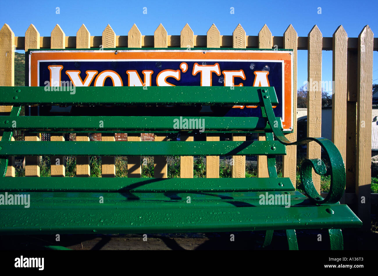 Green bench seat and an old fashioned Lyons Tea advertising sign at