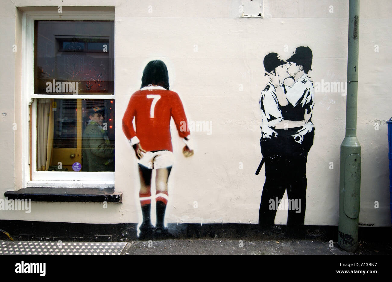 Banksy's famous kissing coppers plus a  George Best rear view, on a wall in Brighton. Stock Photo