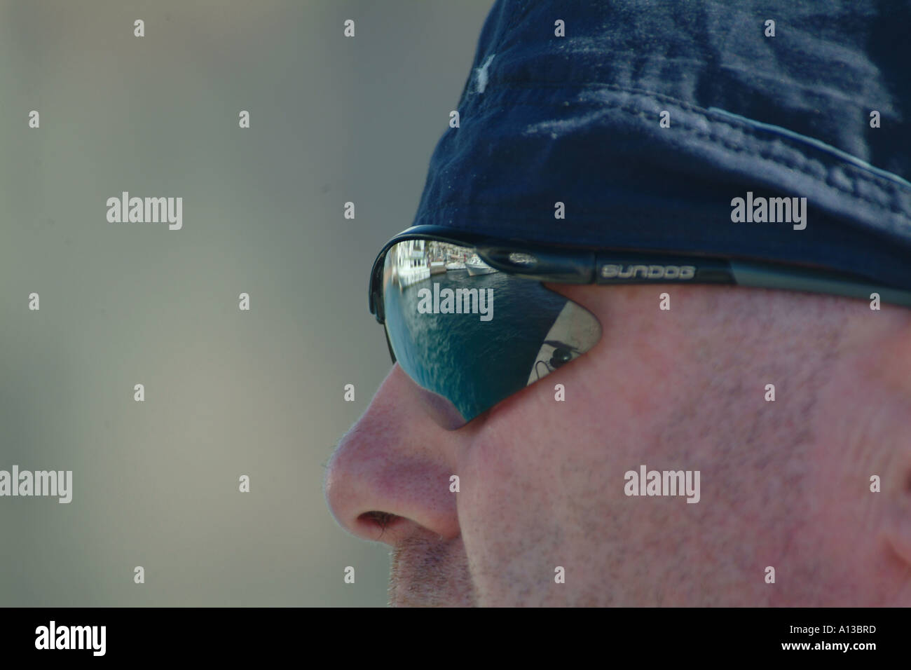 A white male wearing wrap around sunglasses has a image of a marina  reflected in the glasses Stock Photo - Alamy