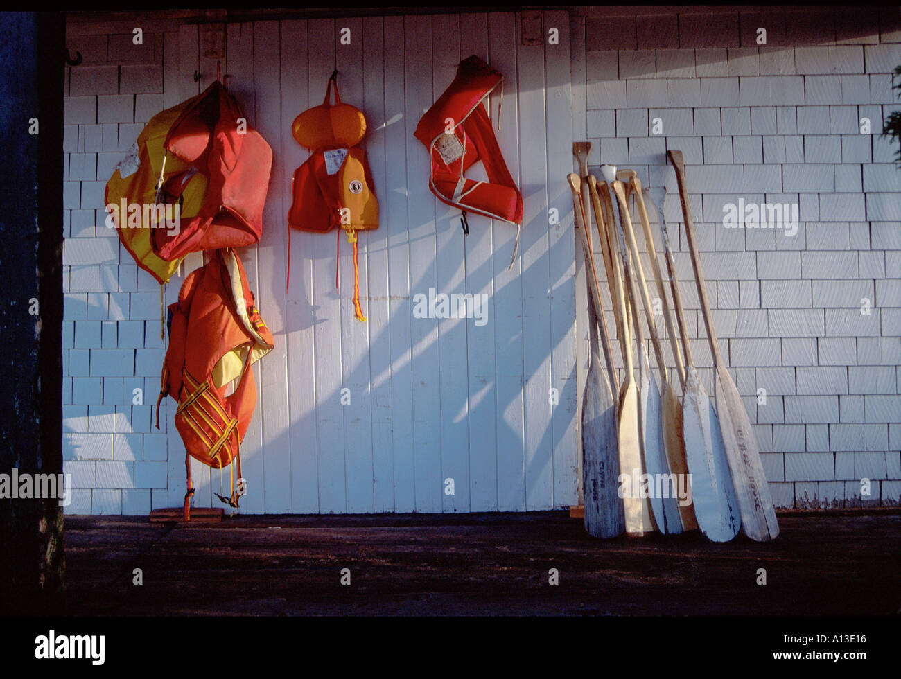 Life jackets and canoe paddles in Boathouse Stock Photo Alamy