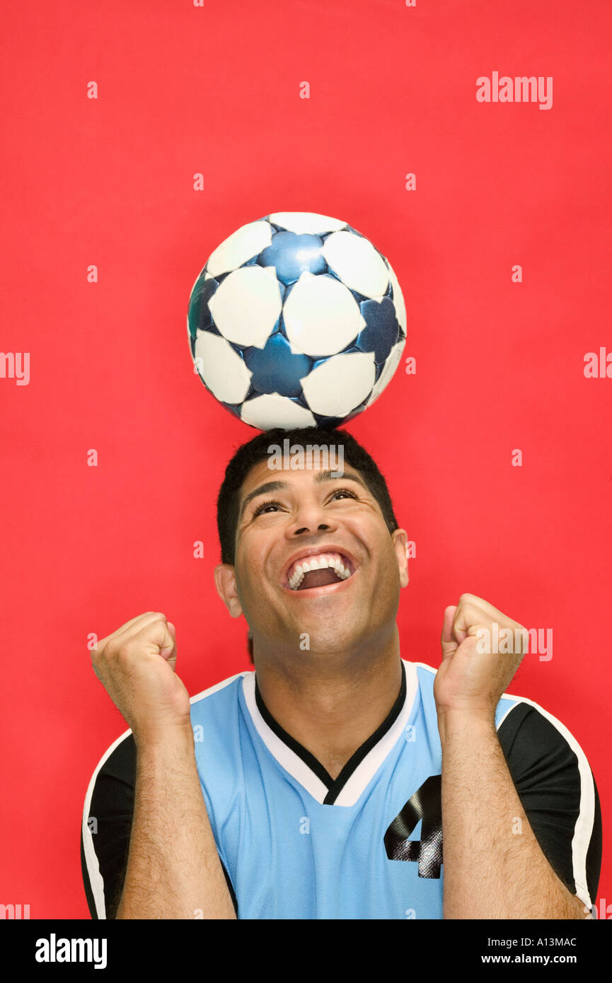 Young man balancing soccer ball on head Stock Photo Alamy