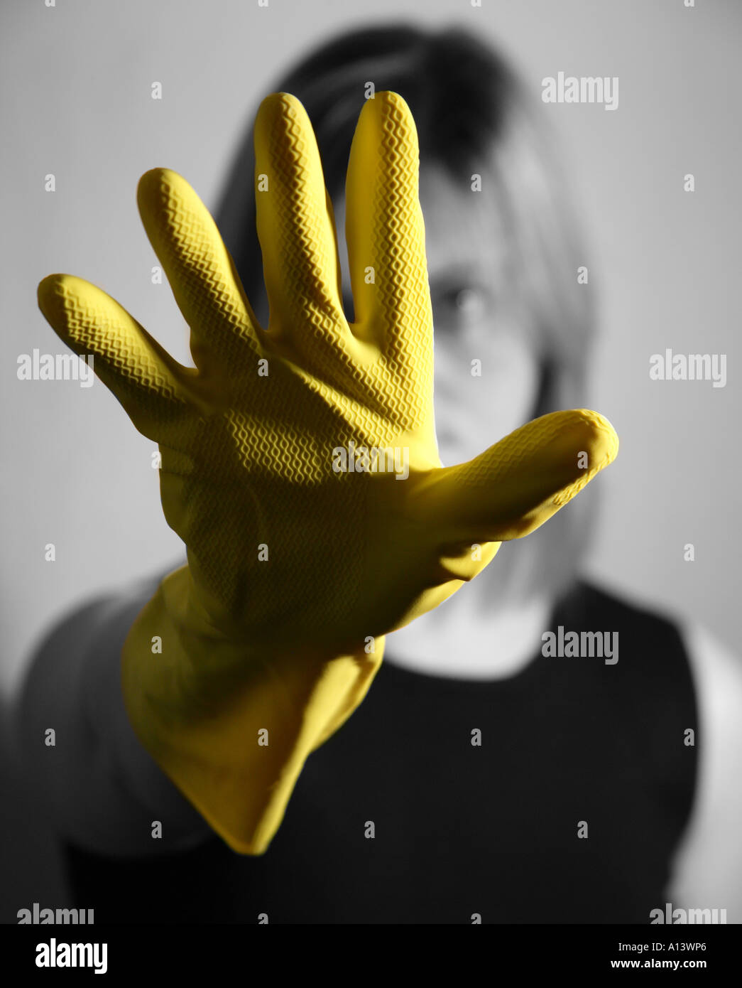 A women holding up her yellow domestic gloved hand in front of her face  whilst she is in black and white Stock Photo - Alamy