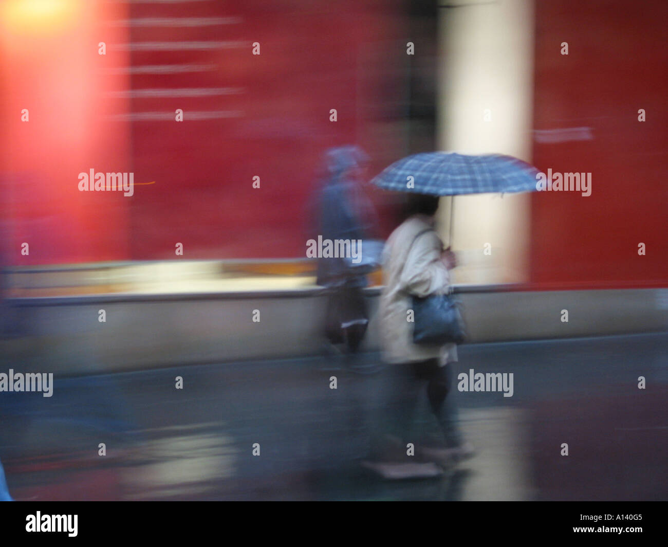 blurred image of pedestrian carrying umbrella in the rain Stock Photo ...