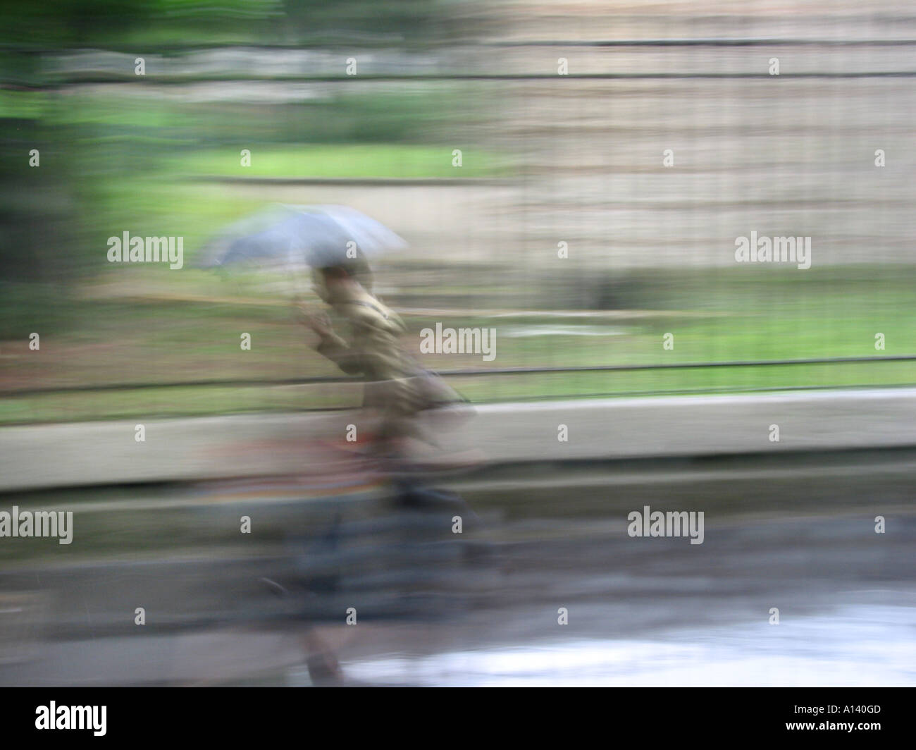 blurred image of pedestrian carrying umbrella in the rain Stock Photo ...