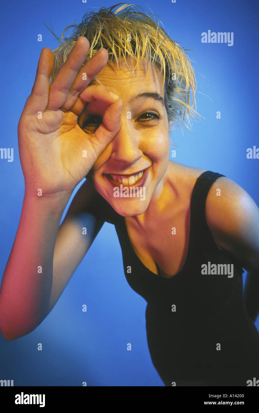 BLONDE HAIR WOMAN SMILING AND DOING GRIMACE Stock Photo