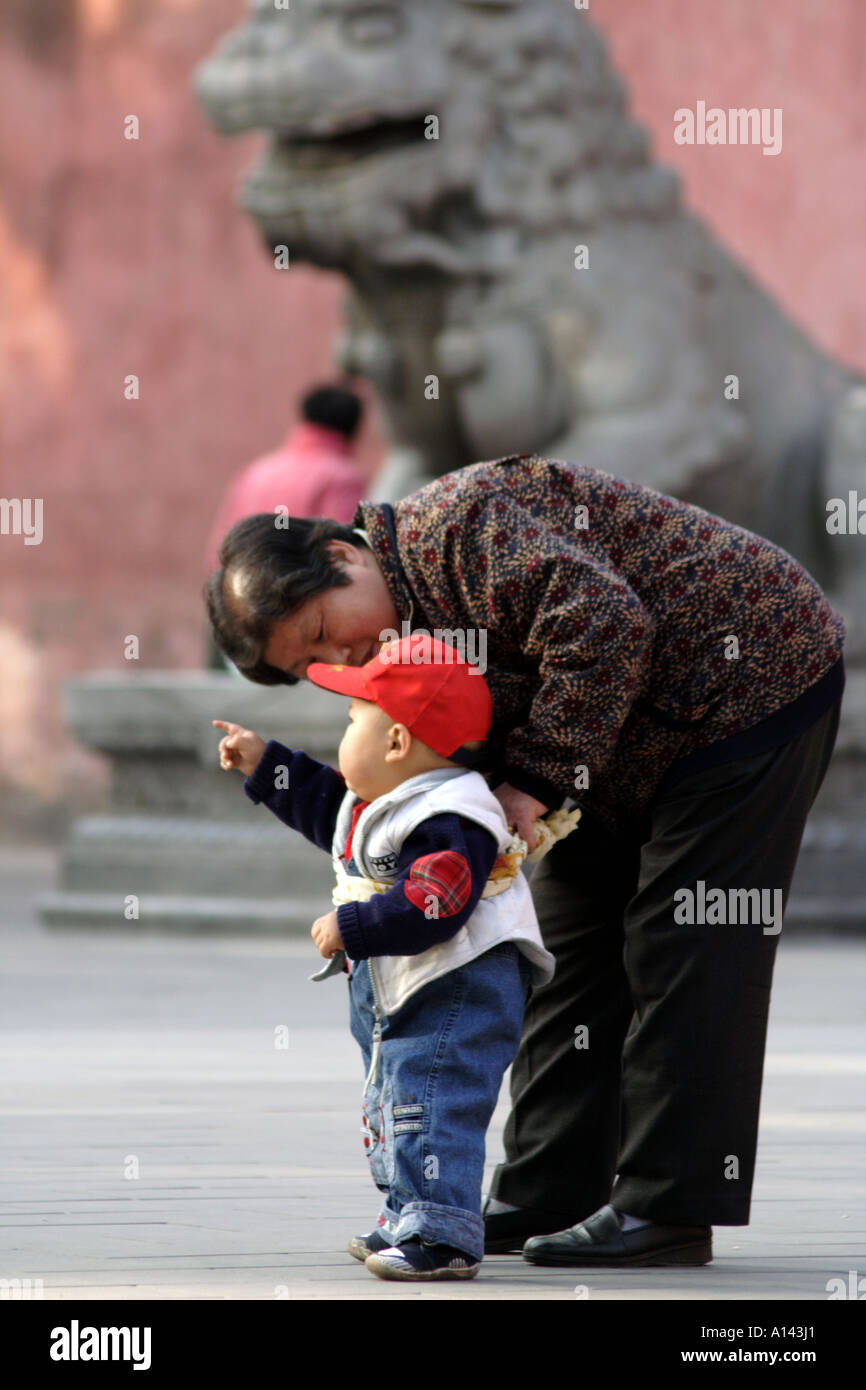 Grandson walks with the help of Grandmother in Jingshan Park, Beijing, China Stock Photo