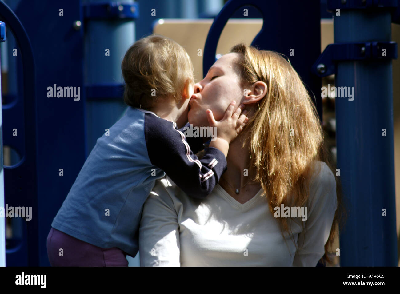 Blond Caucasion Mother Kissing Baby Daughter Stock Photo