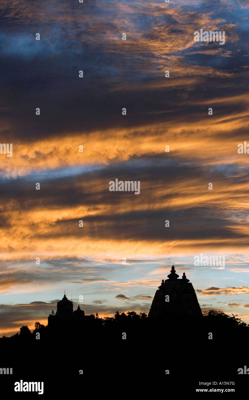 Silhouette profile of Indian ashram architecture against dramatic sunset. Puttaparthi, Andhra Pradesh, India Stock Photo
