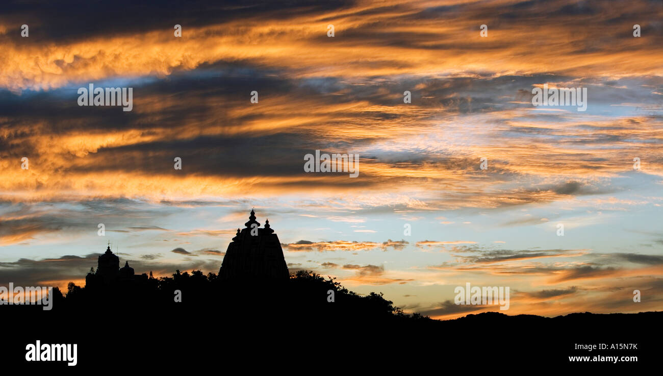 Silhouette profile of Indian ashram architecture against dramatic sunset. Puttaparthi, Andhra Pradesh, India Stock Photo