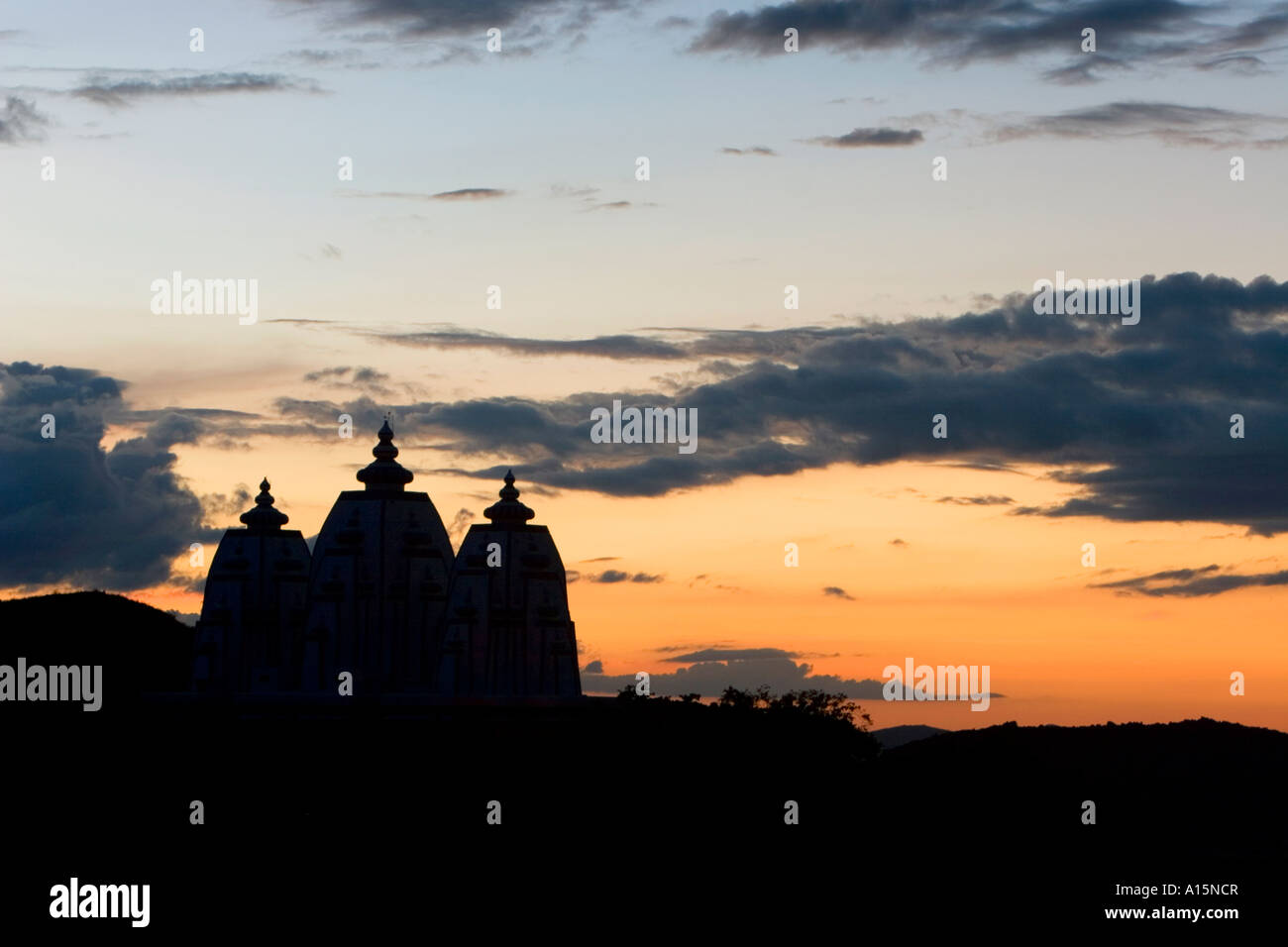 Silhouette profile of Indian ashram architecture against a sunset sky at Puttaparthi , Southern India Stock Photo
