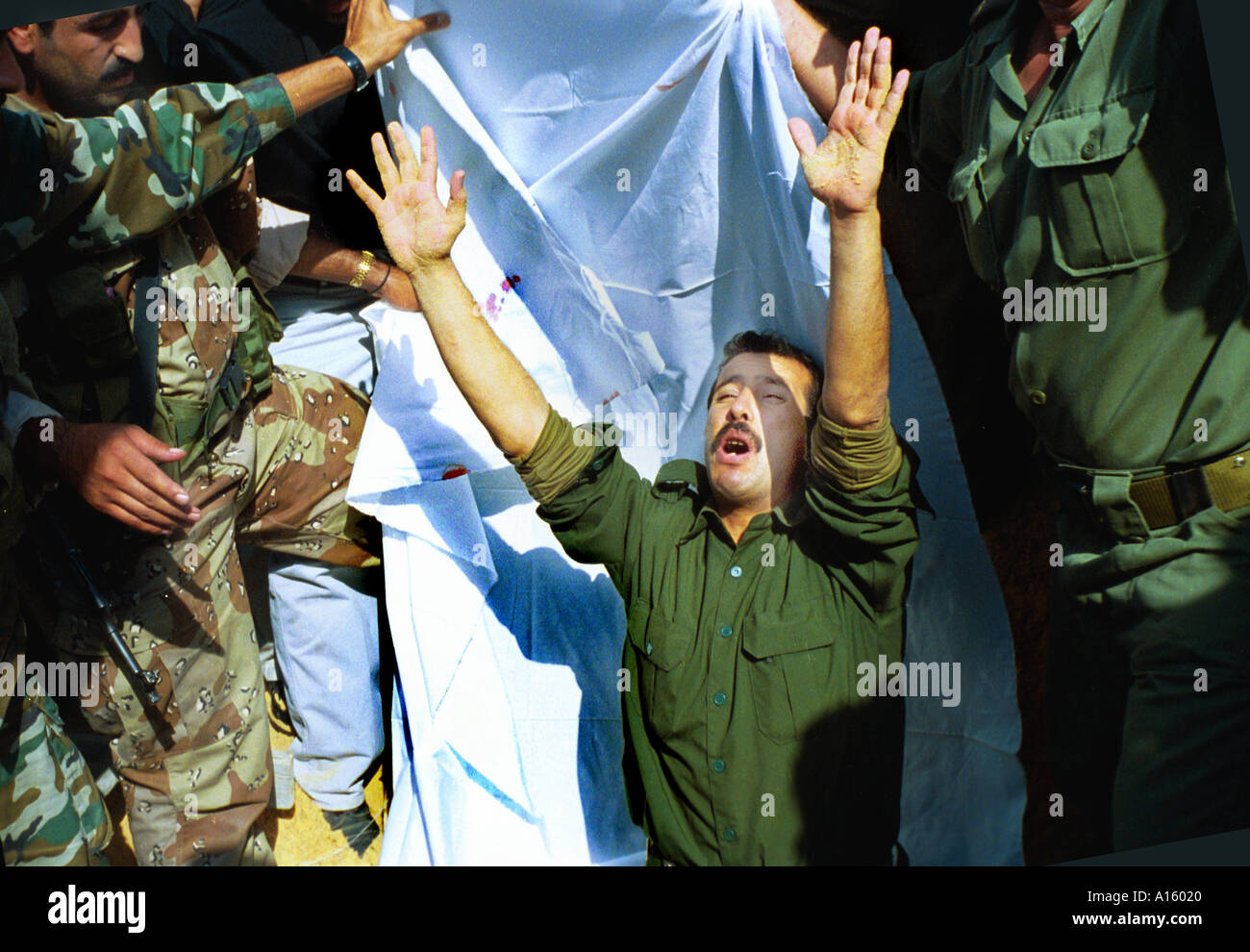 A Palestinian soldier raises his hands and expresses his despair after he buried Musbah Abdelgadr Abu Atig 27 who was killed by Stock Photo