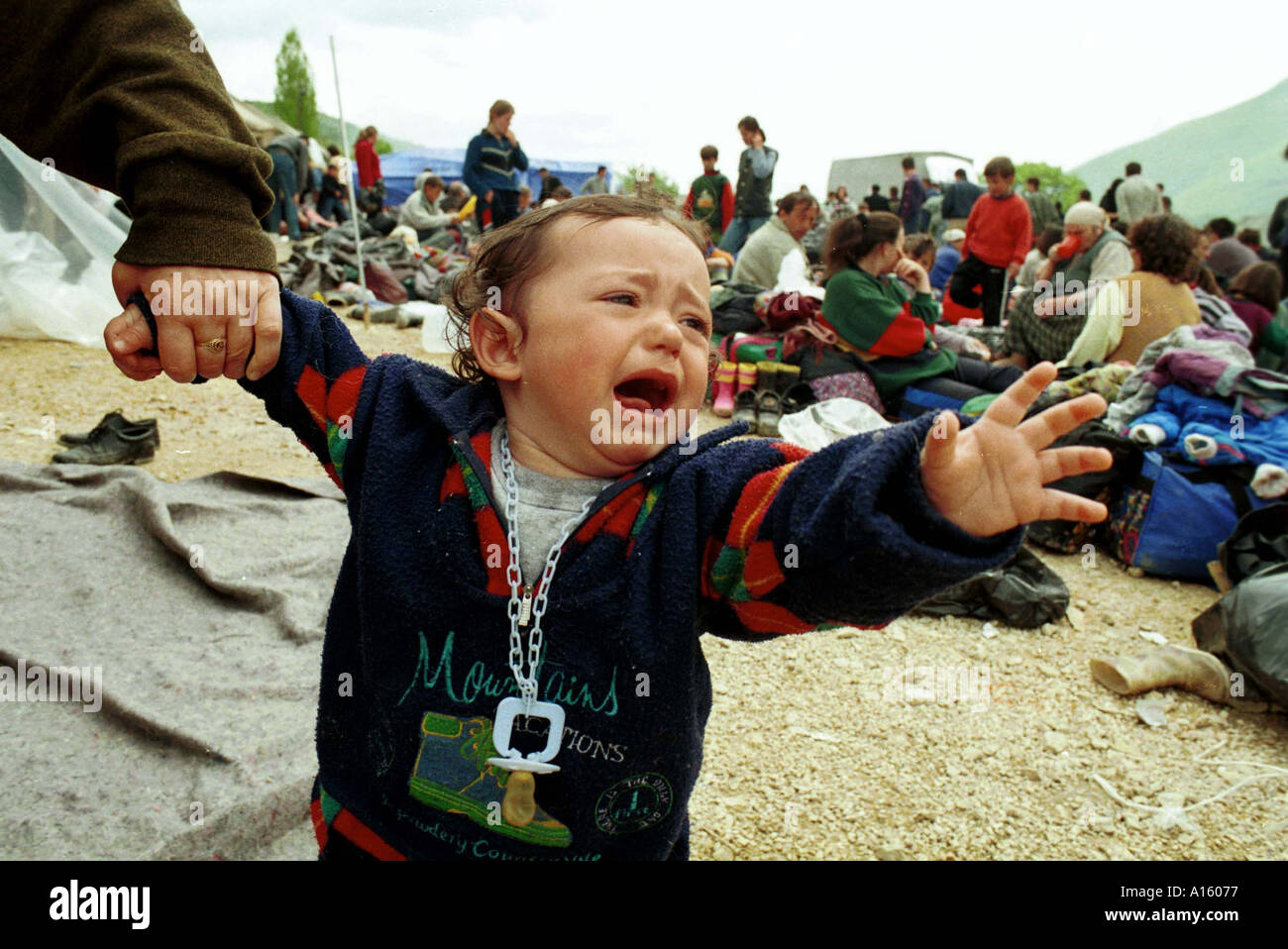 Miran Hyseni 15 months an ethnic Albanian refugees from from Ferizai Kosovo cries out while waiting in the transit camp at the Stock Photo