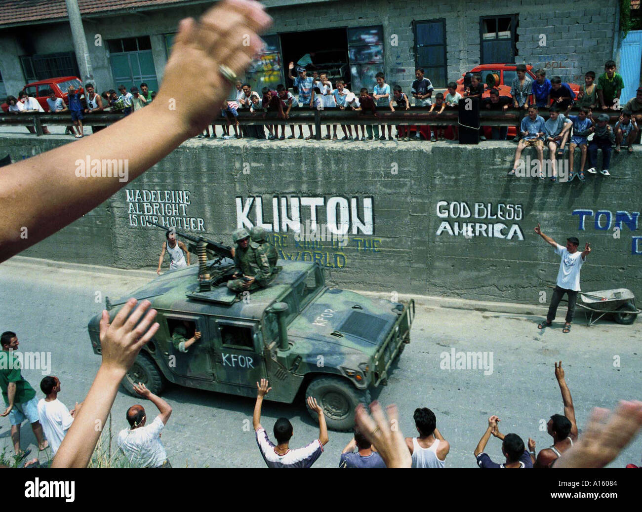 Ethnic Albanians greet American NATO troops as they drive by the town of Gnjilane Wednesday June 30 1999 in Kosovo. Stock Photo