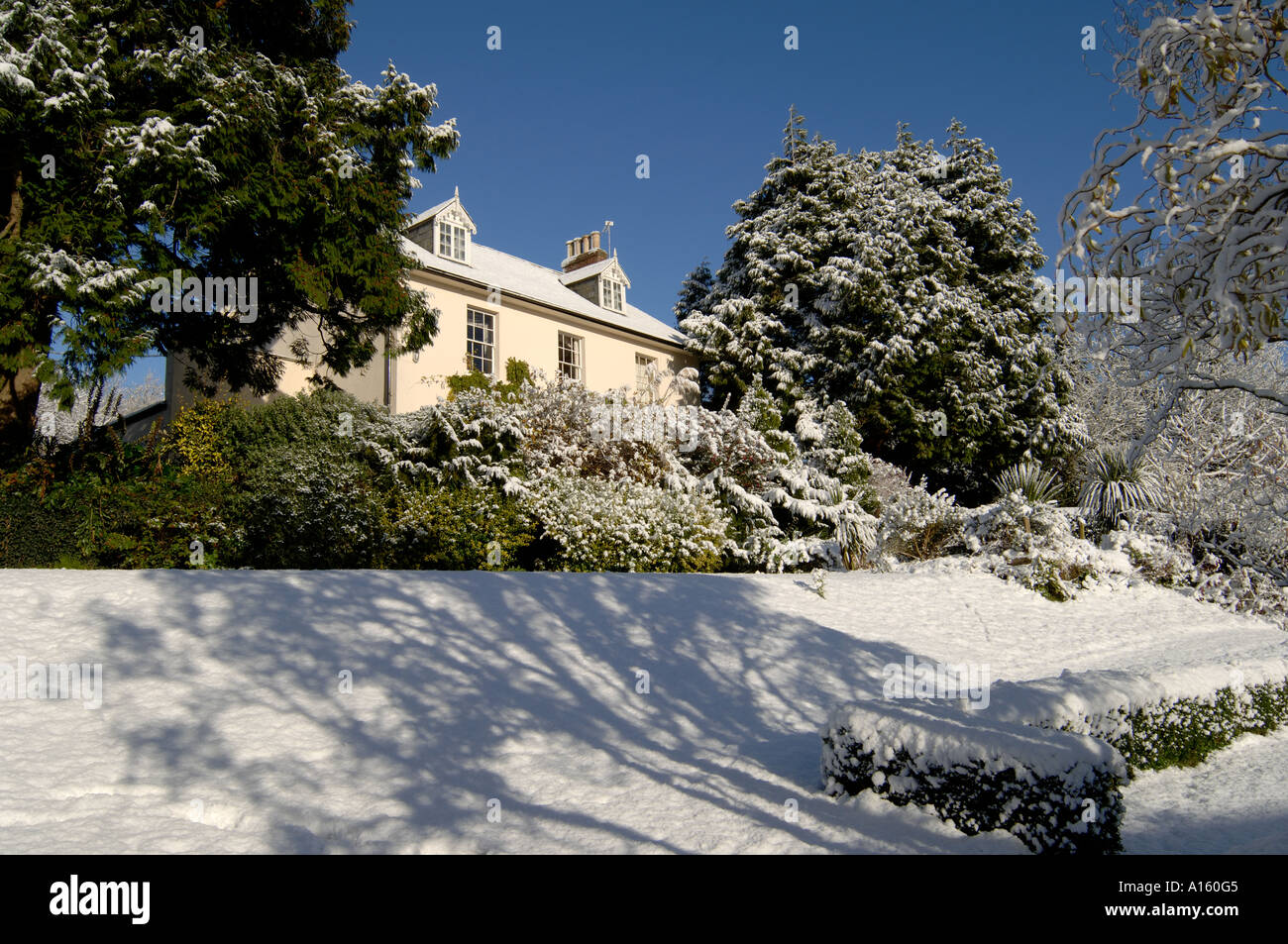 A Georgian house and garden after a heavy snow fall with sun blue sky Stock Photo
