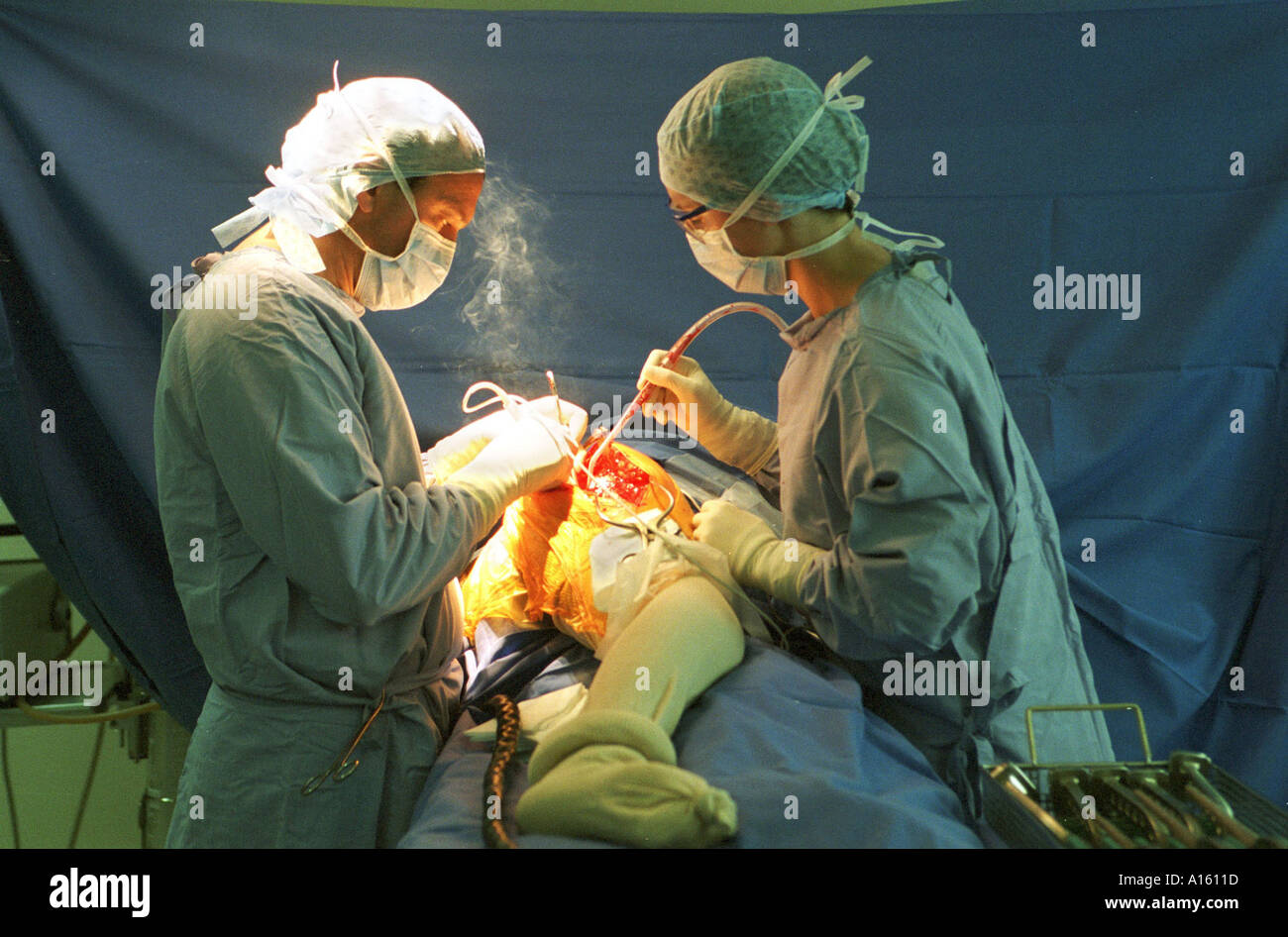 Doctors perform surgery on a woman's hip at the private hospital Centre Medico-Chirurgical and Maternite De Tronquieres in Stock Photo