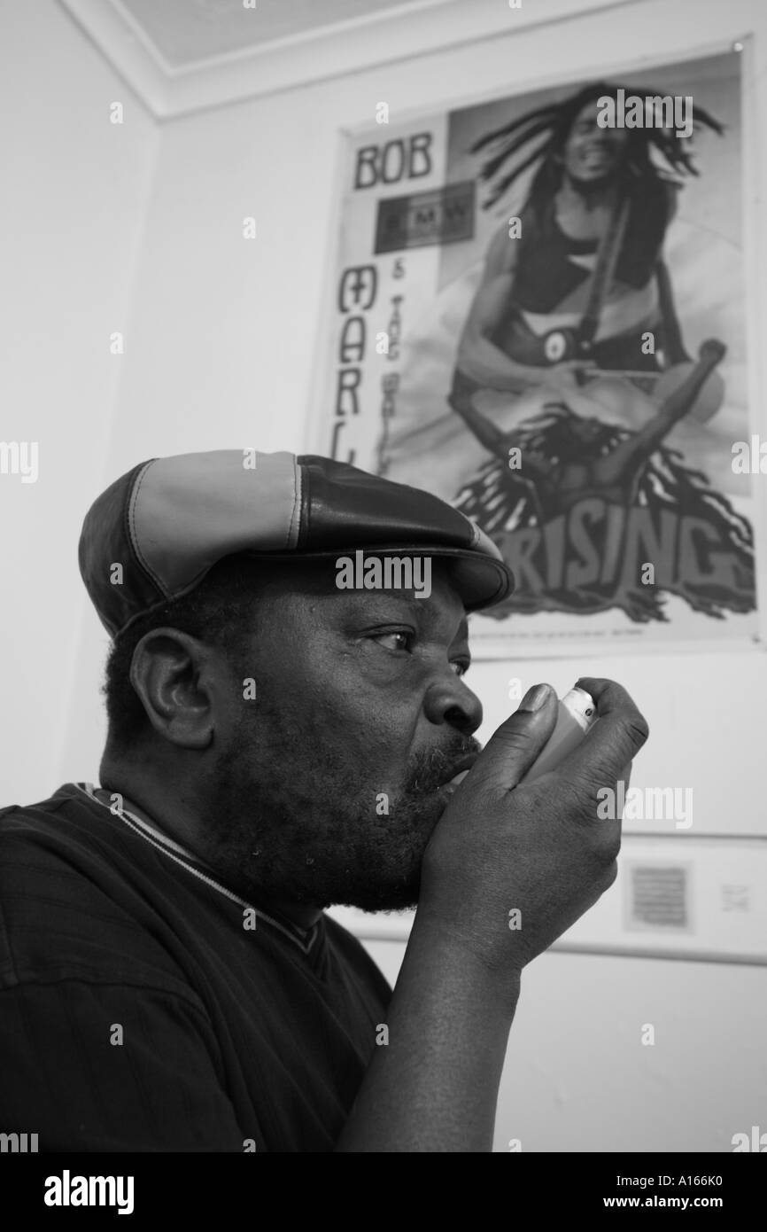 Black and white portrait of Jamaican man using asthma inhaler Stock Photo
