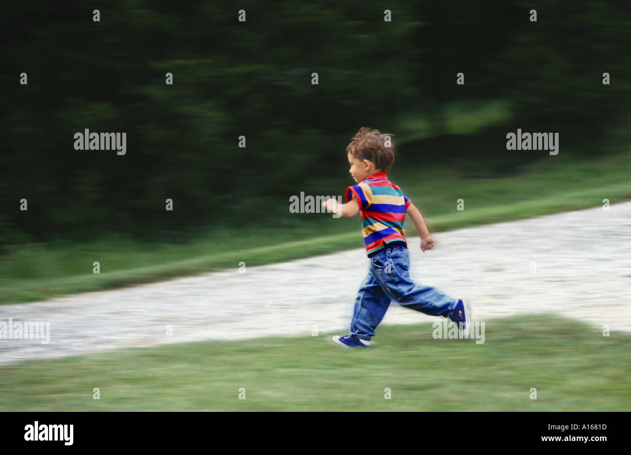 Fast as the wind: young boy ~ 4 years old running fast in his yard, Midwest USA Stock Photo