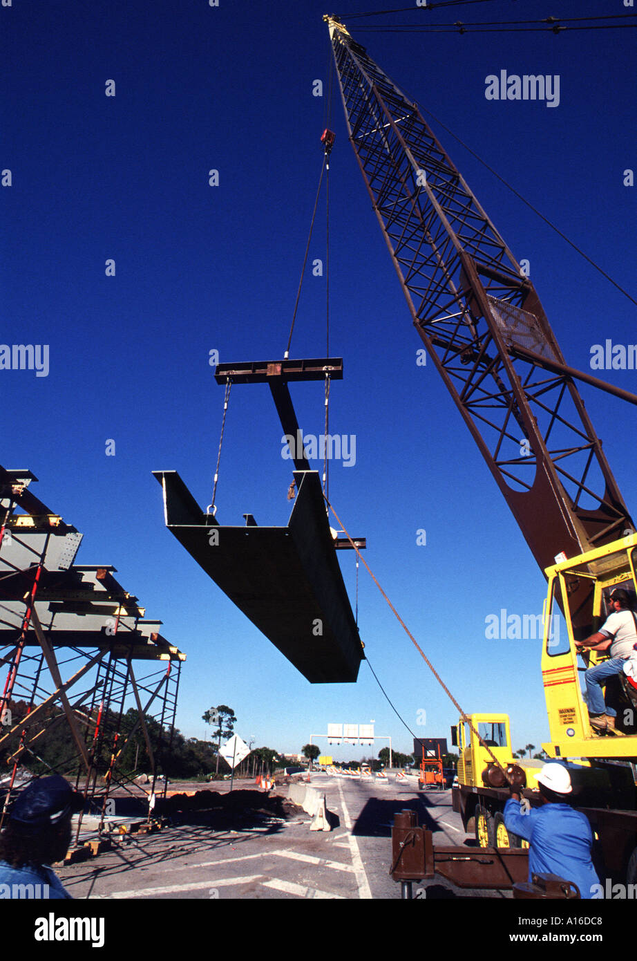 Construction Crane lifting heavy I beam into place Stock Photo Alamy