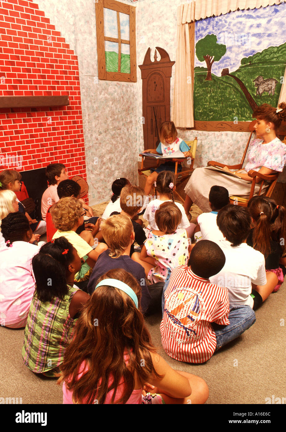 Education 1st grade class reading mixed races with teacher Stock Photo