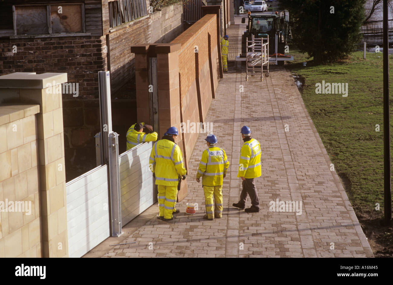 Environment Agency workers erecting flood barriers by the Welsh bridge at Frankwell, Shrewsbury Stock Photo