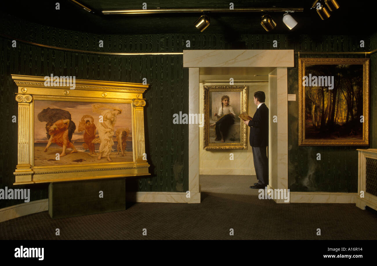 Art dealer 1990s in his gallery with paintings Belgravia Art Gallery