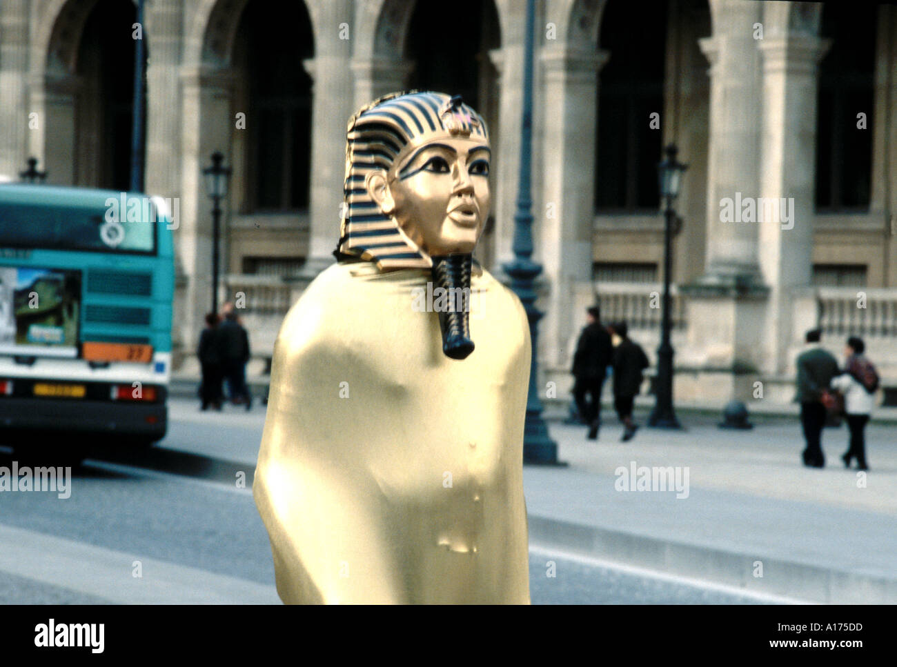 Outside the Louvre in Paris France a street entertainer performs dressed as an Egyptian mummy Stock Photo