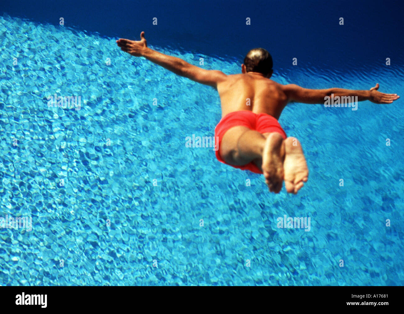 Middle aged man diving into swimming pool Stock Photo - Alamy