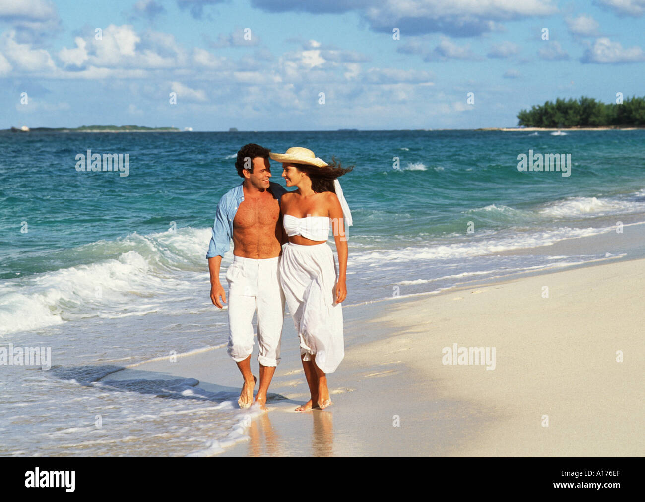 Attractive young couple walking on the beach Stock Photo