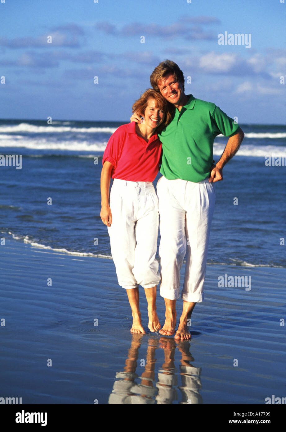 Attractive middle aged couple walking on the beach Stock Photo