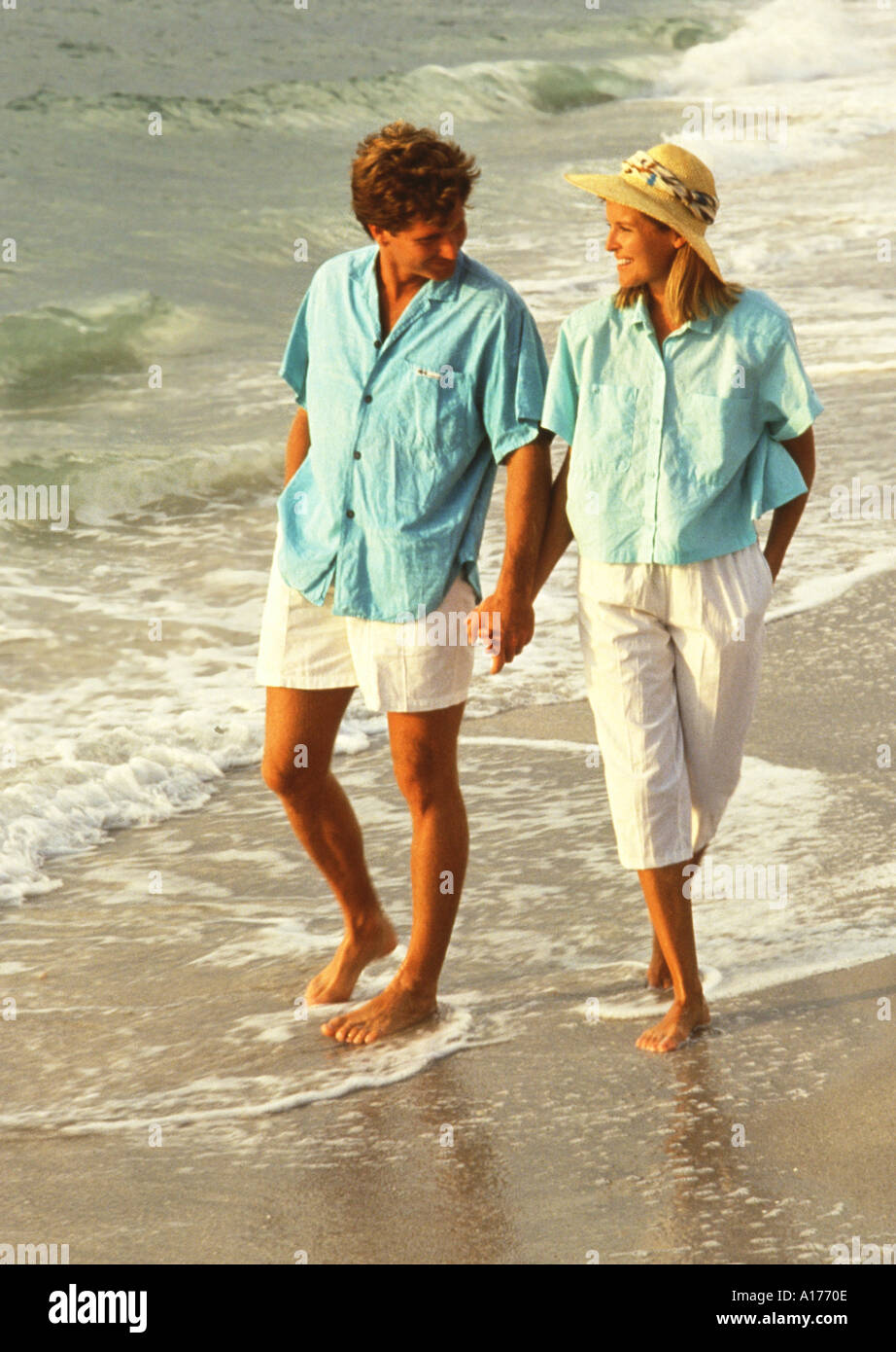 Attractive middle aged couple walking on the beach Stock Photo