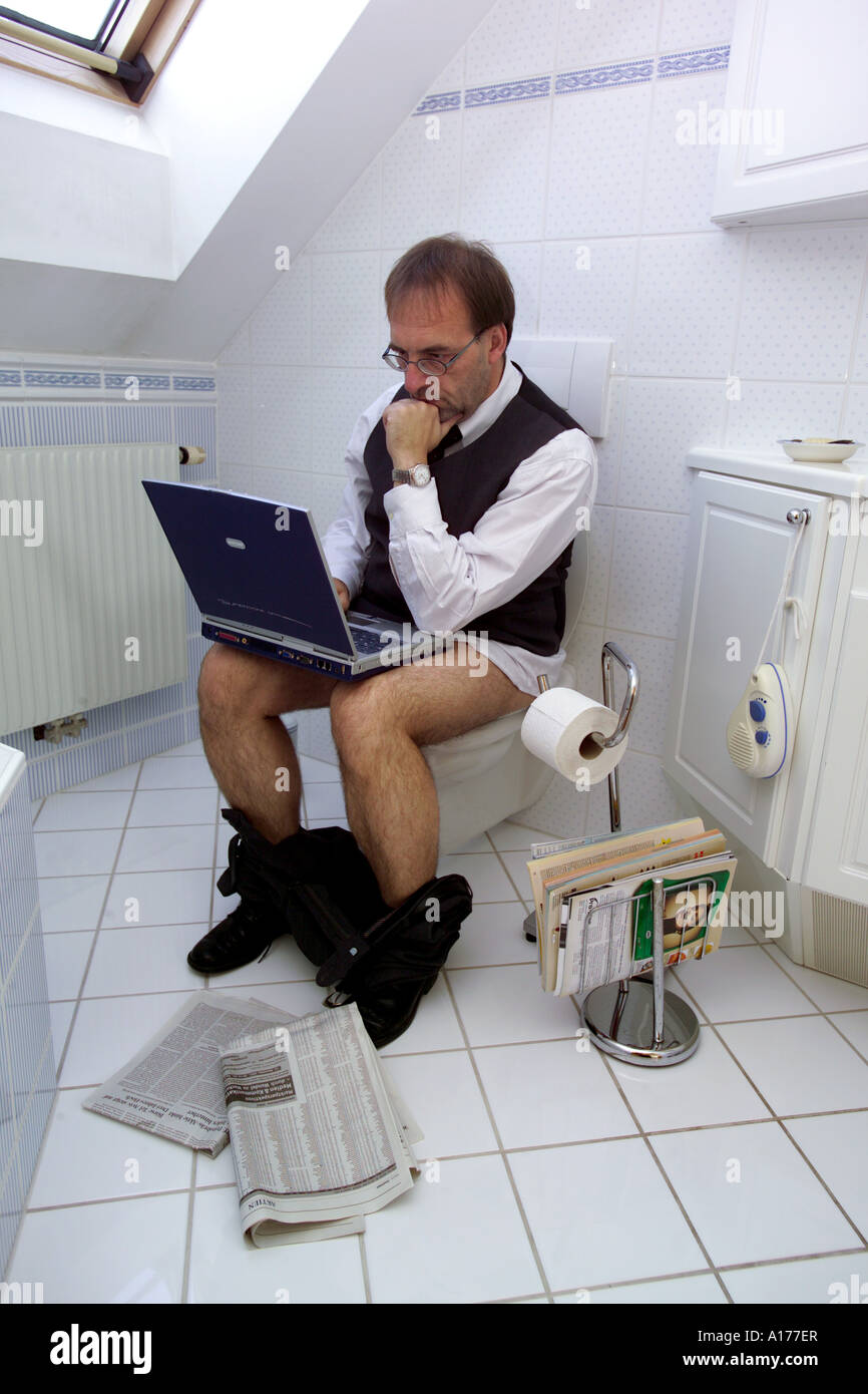 Man with computer in the toilet Stock Photo - Alamy