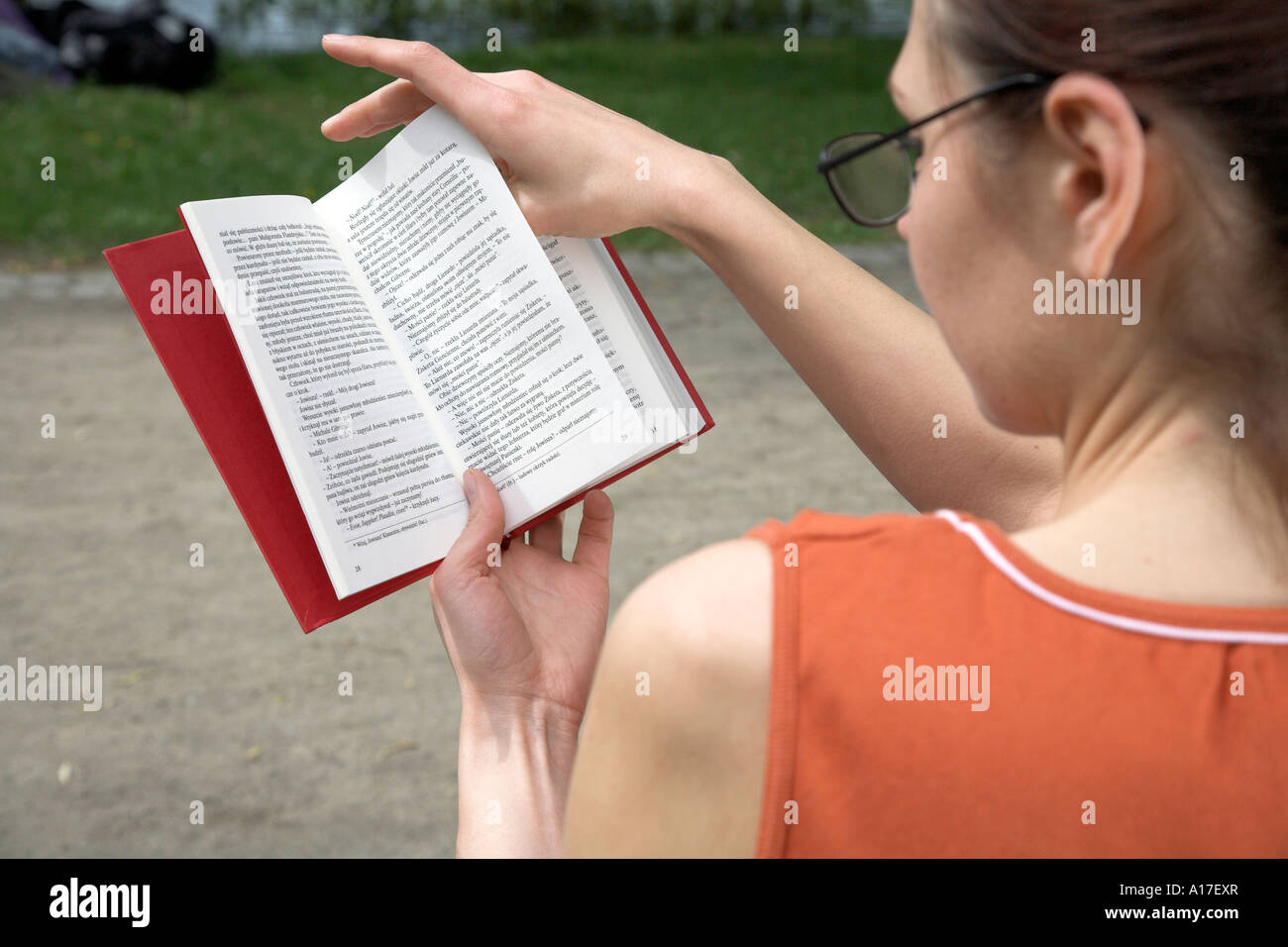 Woman sitting in a park and reading a book Stock Photo - Alamy