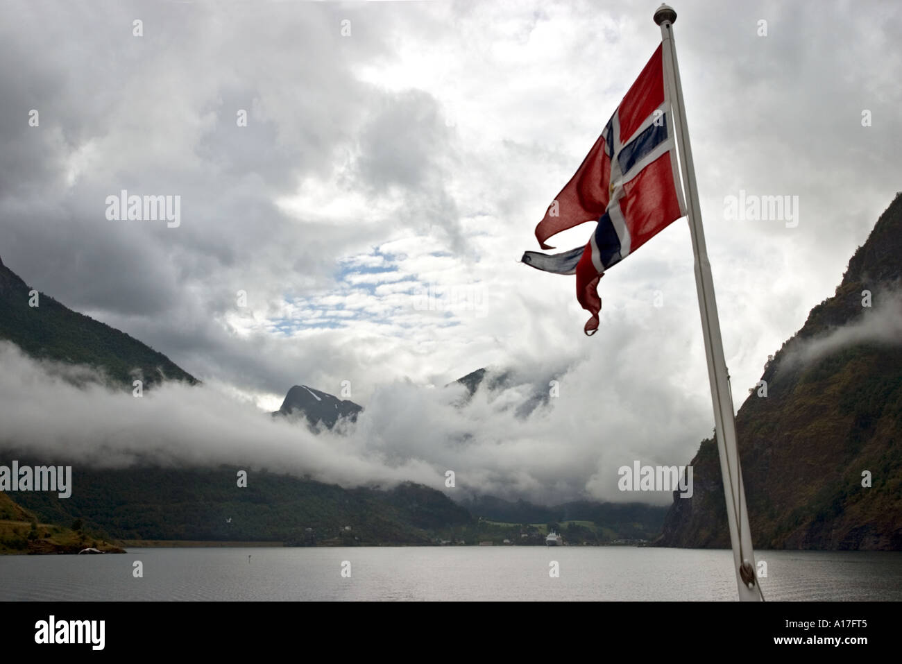 Low clouds over Aurlandsfjord with Norwefian flag in foreground Norway Stock Photo