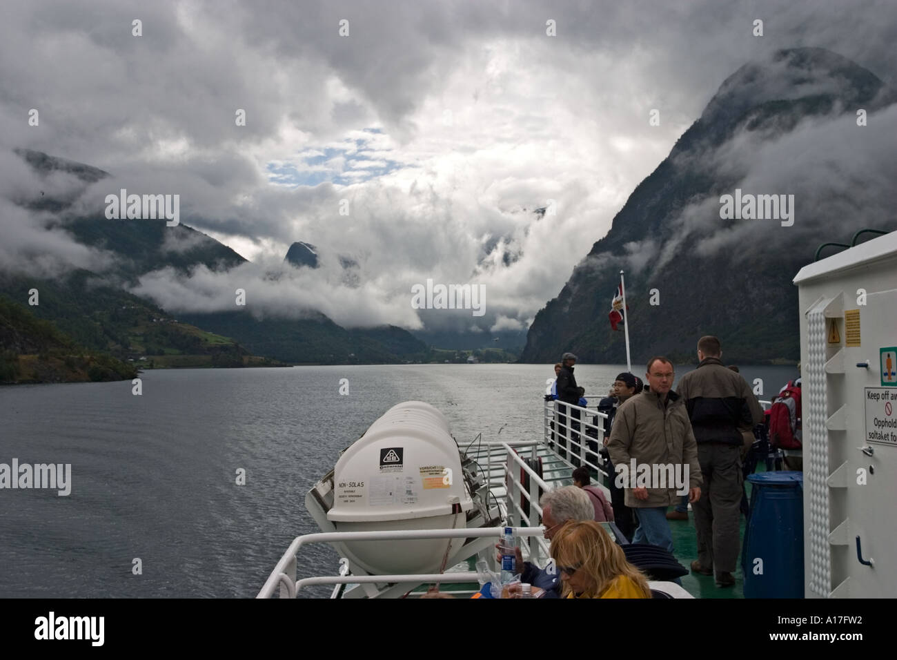 Low clouds over Aurlandsfjord with part of excursion boat in foreground Norway Stock Photo