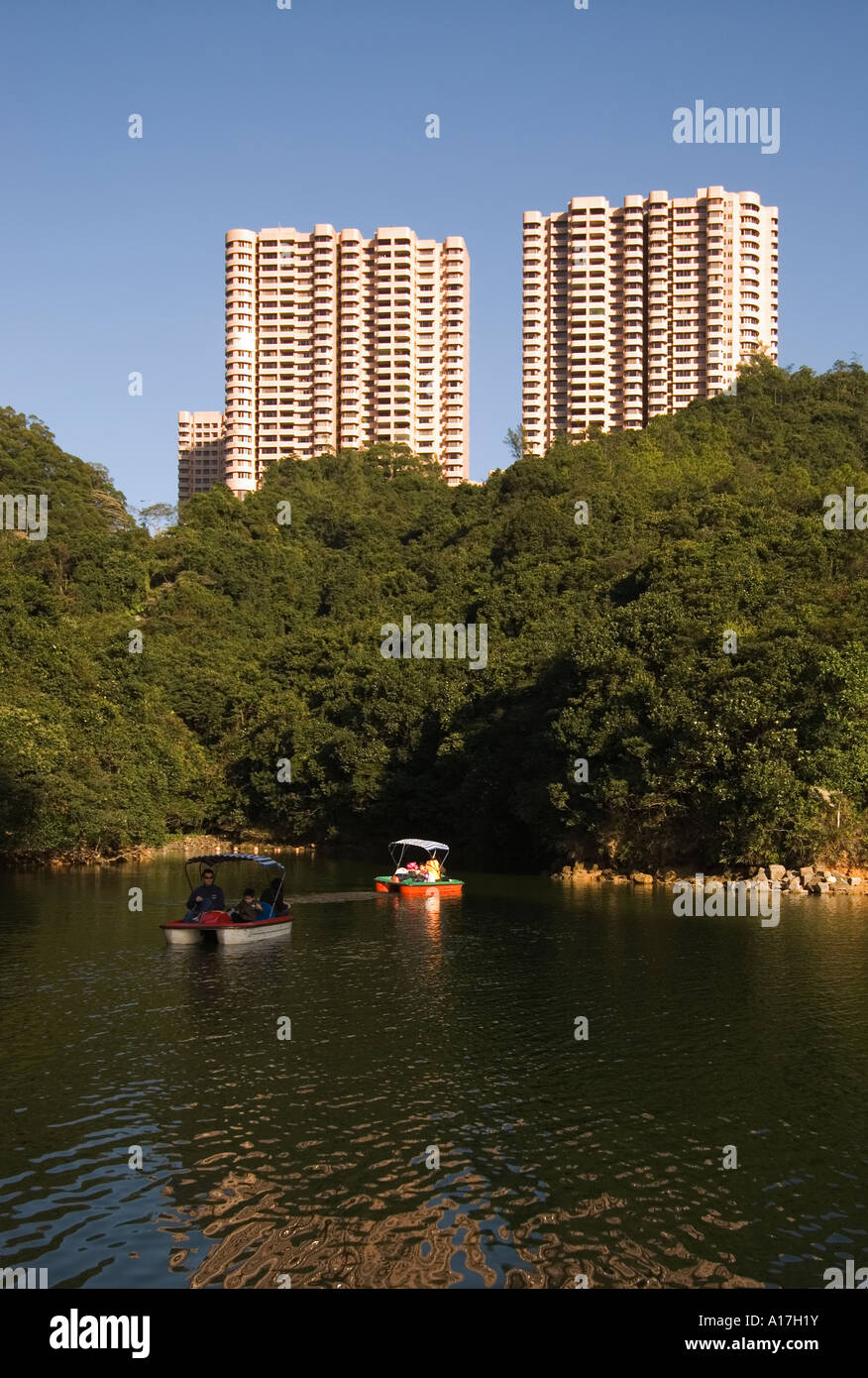 Paddleboats in a reservoir  in front of the Hong Kong Parkview residential complex at Tai Tam Country Park Hong Kong SAR China Stock Photo