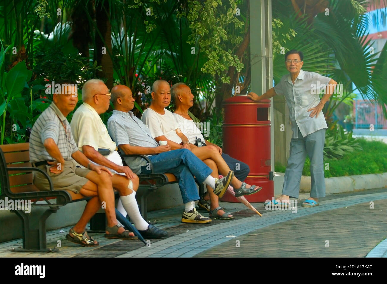A group of elderly Chinese men relax in a park in Hong Kong Stock Photo