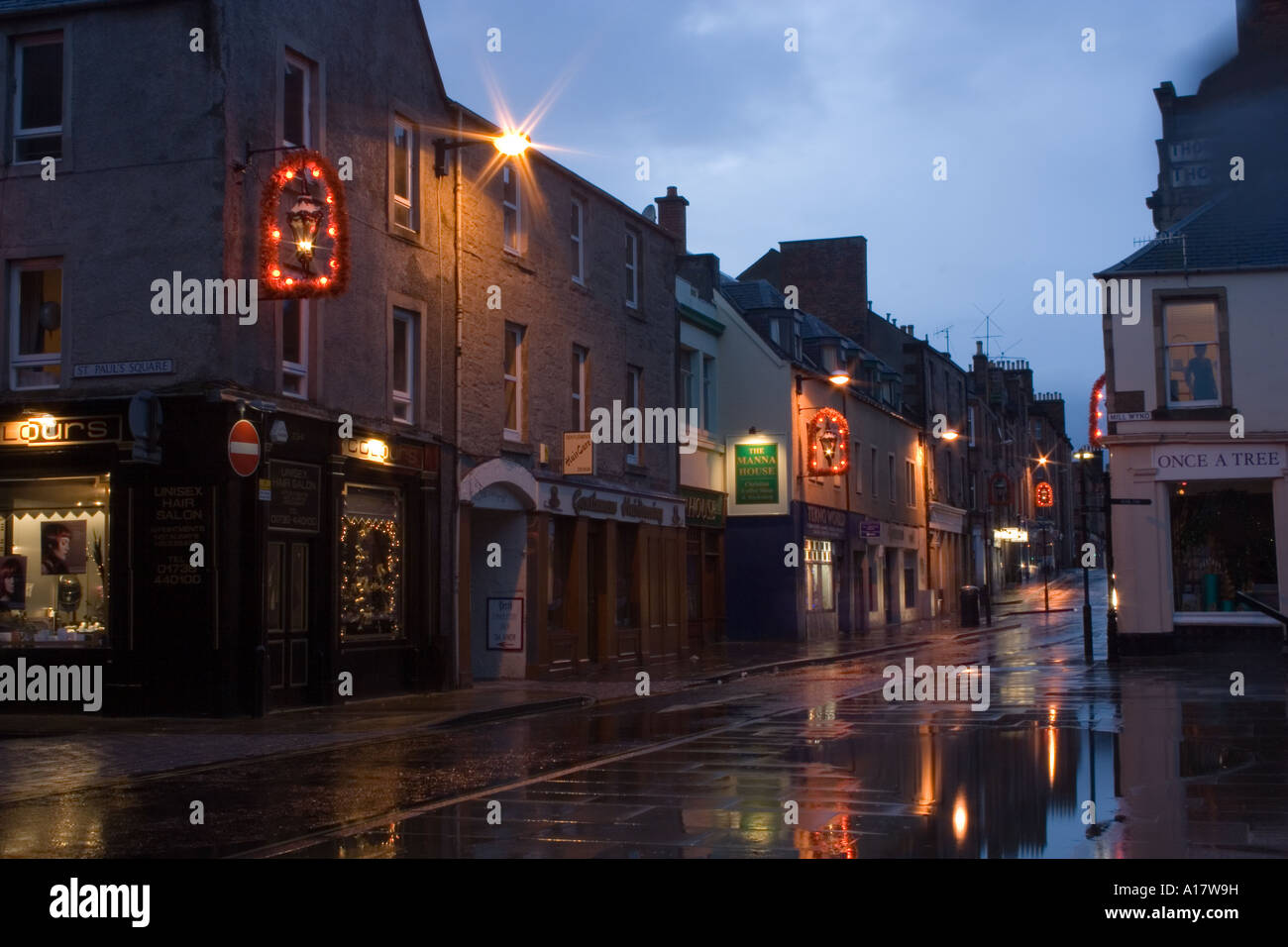 Christmas decorations and reflections from shop lights decorate Perth town in the pouring rain; UK Stock Photo