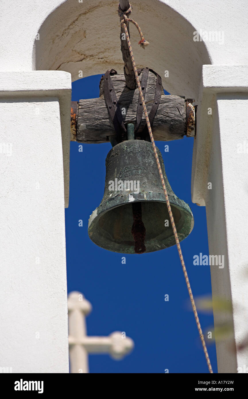 Closeup of bell with wooden hanging yoke in arch of church bell tower Lefkes Island of Paros Greece Stock Photo