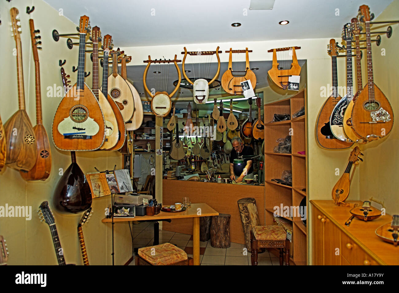 Stringed instruments displayed in shop and a craftsman instrument maker Stock Photo