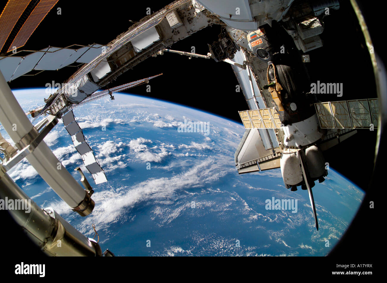 The docked Space Shuttle Atlantis (STS-115) and a Soyuz spacecraft backdropped by the blackness of space and Earth's horizon. Stock Photo