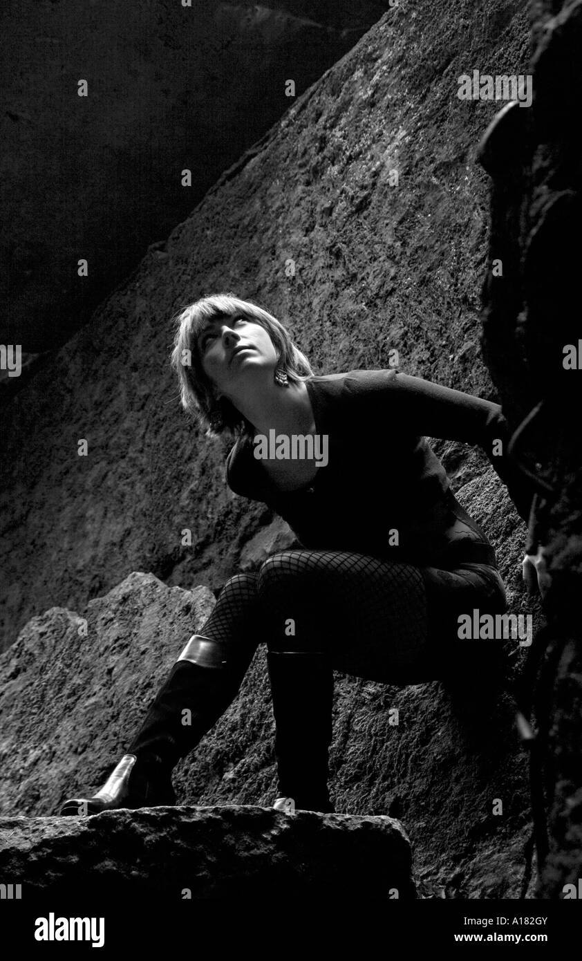 portrait of young woman looking up at the light surrounded by ruins Stock Photo