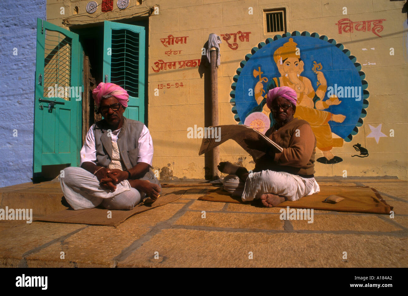 Two men sitting outside one reading a newspaper Jaisalmer India Robert Harding Stock Photo
