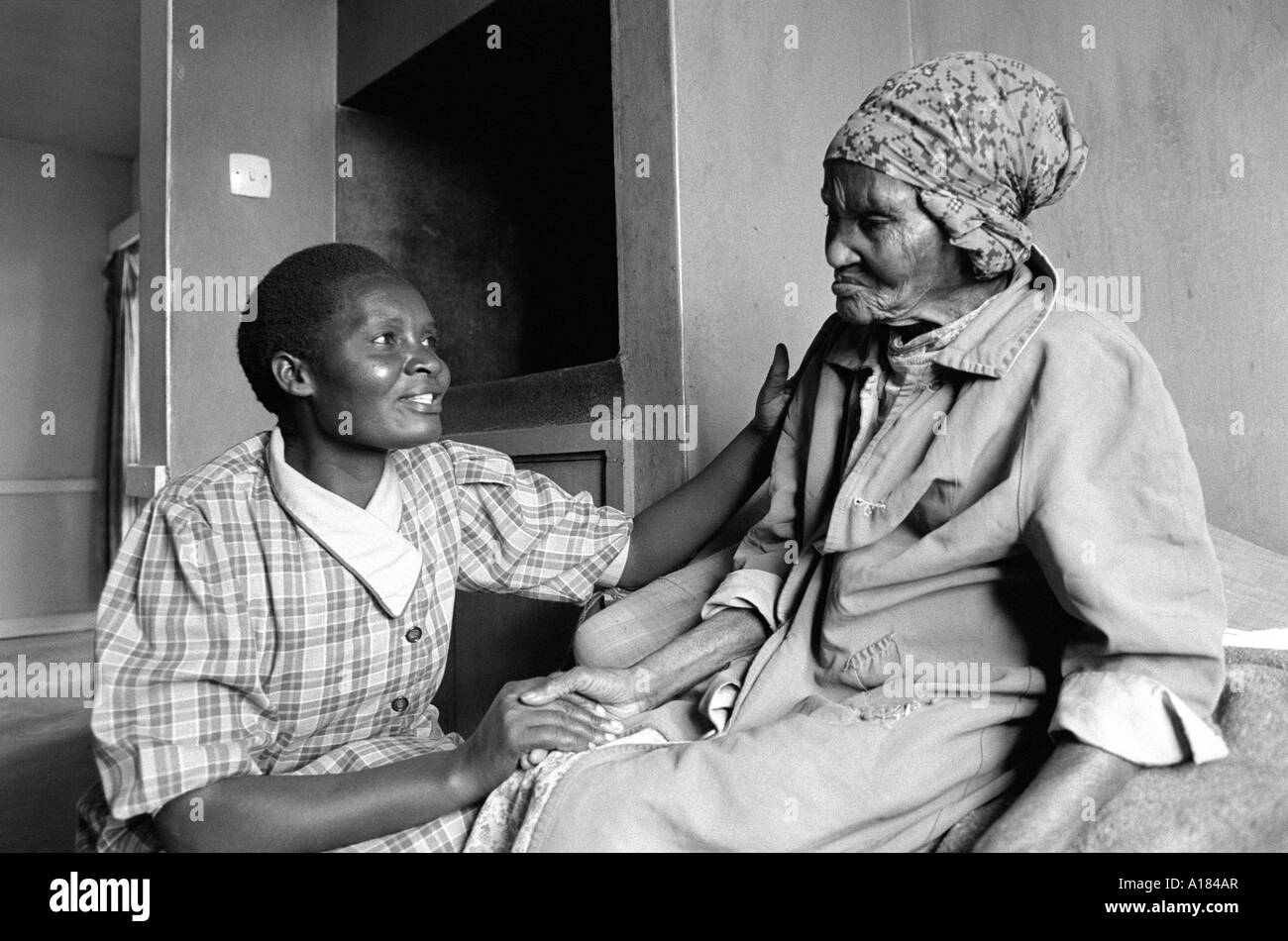 B/W of a female carer looking after an elderly resident in a care home. Kabete, Kenya Stock Photo