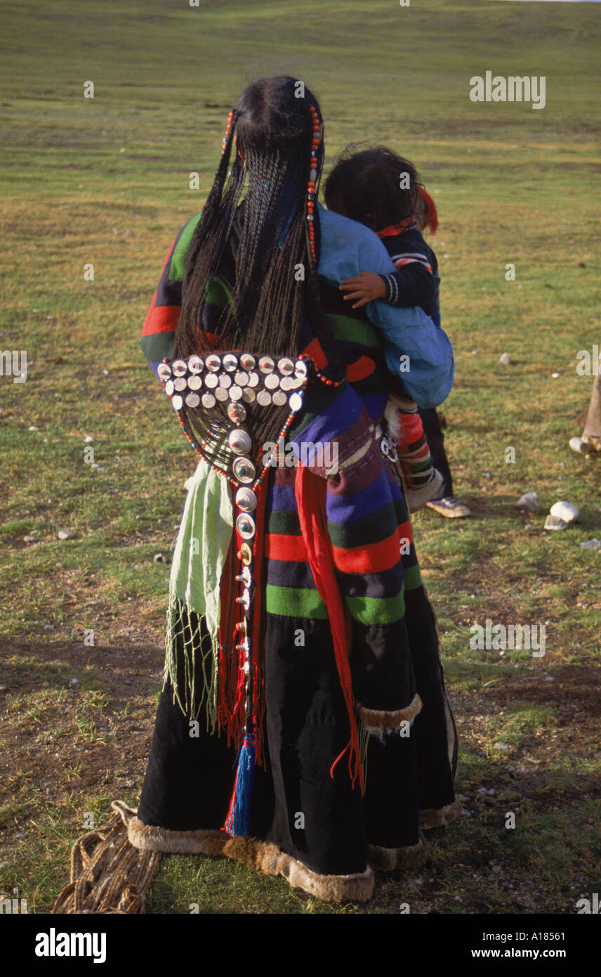 Back view of a traditional Tibetan dress with silver ornaments on long platted hair worn by yak herder apos s wife north of Stock Photo