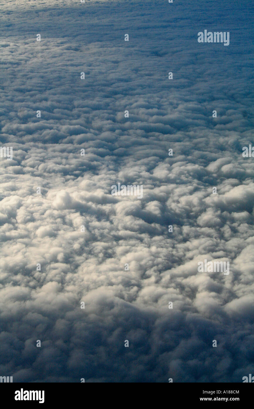 Flying above clouds - stunning view from a plane soaring above a layer of fluffy clouds Stock Photo