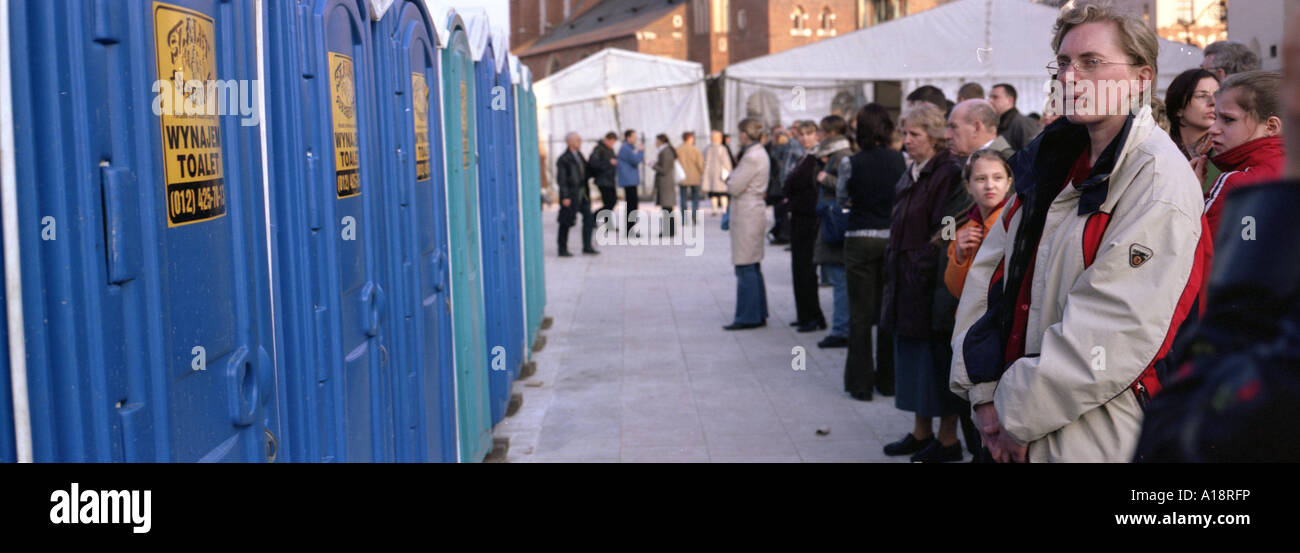 A queue of people waiting to use temporary outsidestyle toilets in Krakow Poland Stock Photo