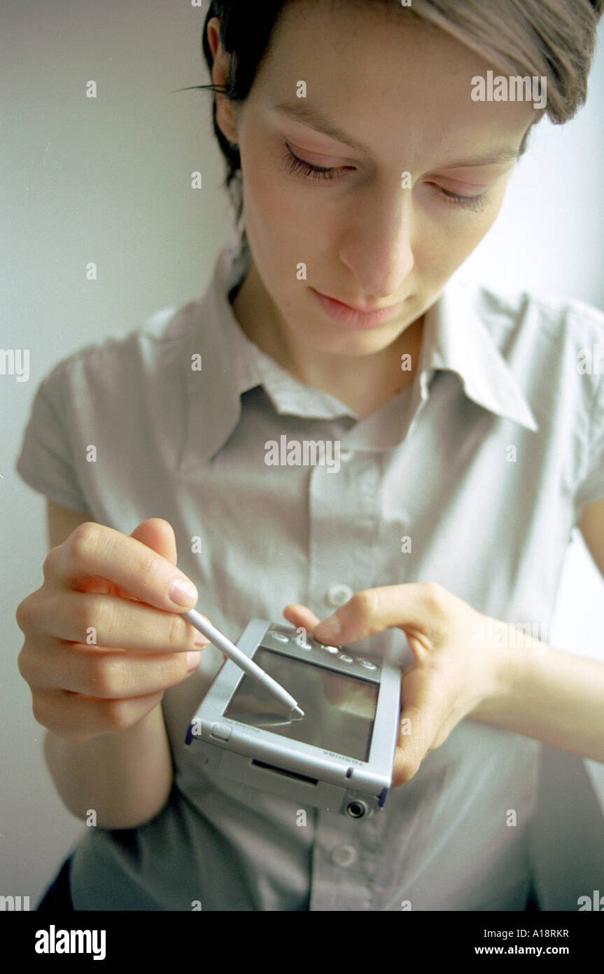 Girl working on a palmtop computer Stock Photo
