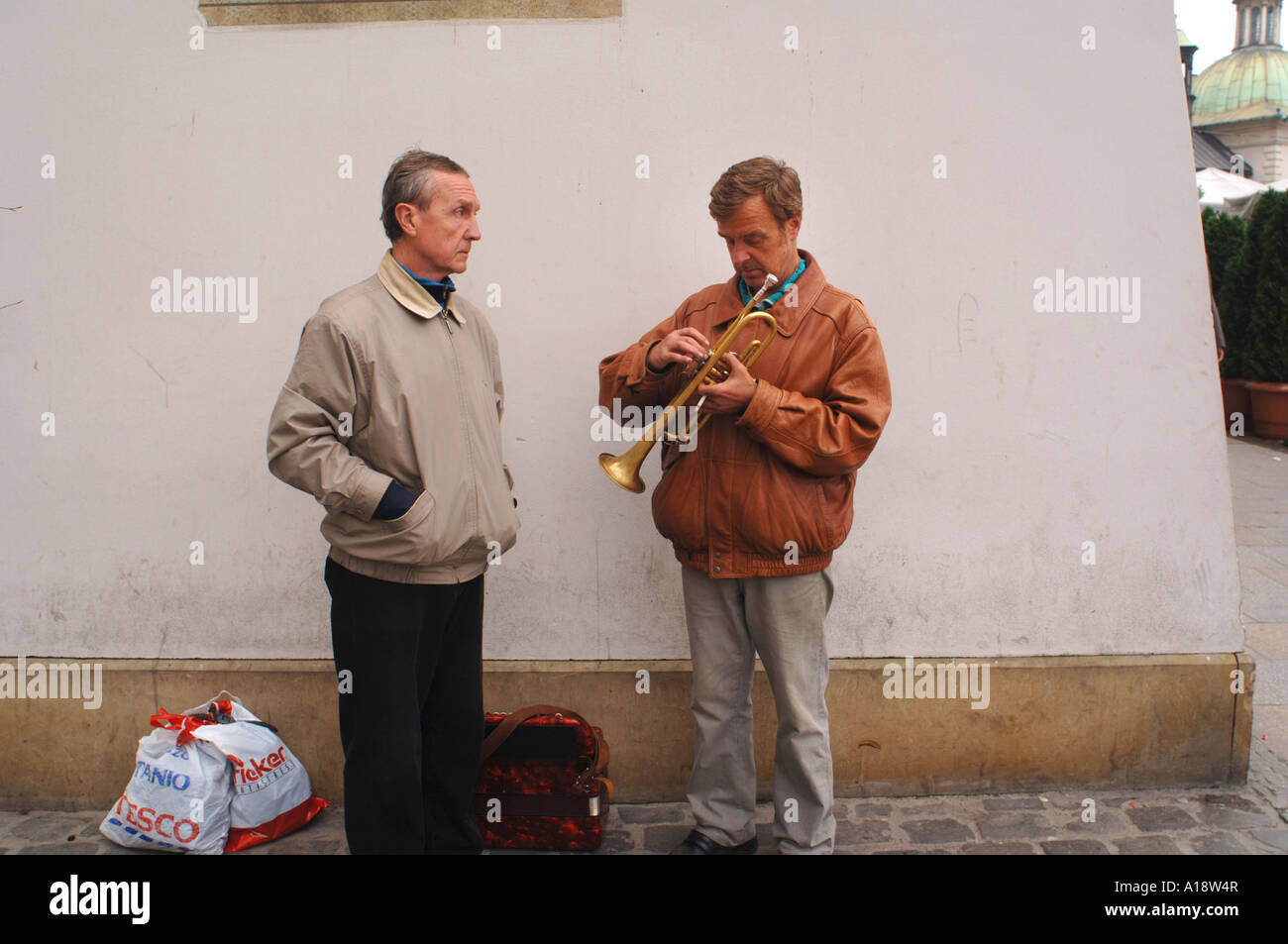 A busker prepares his trumpet on Krakow s Main Market Square Stock Photo