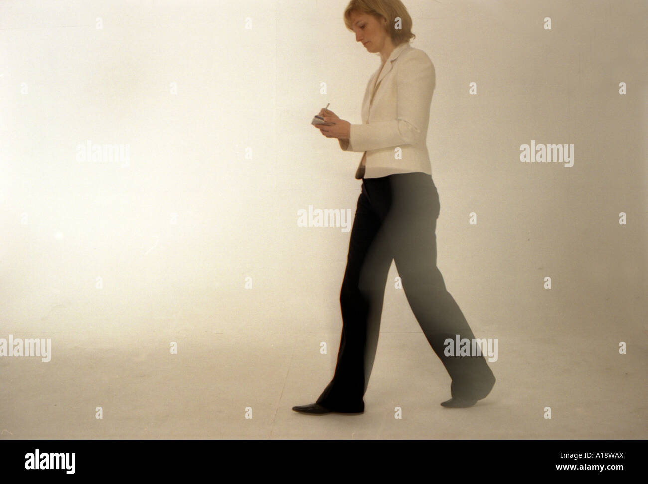 A business woman walking consulting a palmtop computer Stock Photo